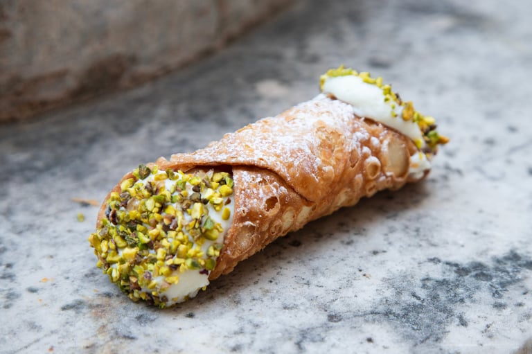 Delicious Sicilian cannoli pastry filled with sweet cream and pistachios in Palermo, Sicily, Italia.